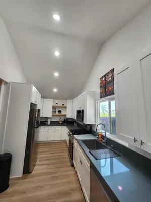a kitchen with white cabinets and a black counter top at Best Location pet friendly Home just renovated in Chula Vista