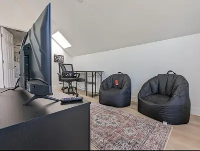 a living room with a flat screen tv and two chairs at Best Location pet friendly Home just renovated in Chula Vista