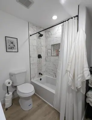 a bathroom with a toilet and a bath tub with a shower curtain at Best Location pet friendly Home just renovated in Chula Vista