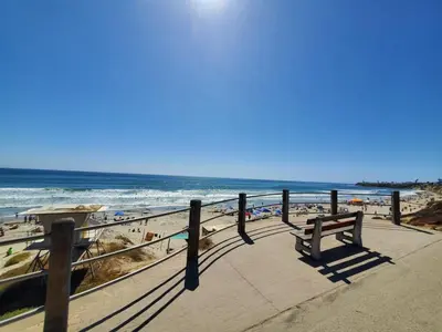 a bench sitting on a boardwalk near the beach at 500 ft to Ocean Relaxing stay Parking WiFi 838 in San Diego
