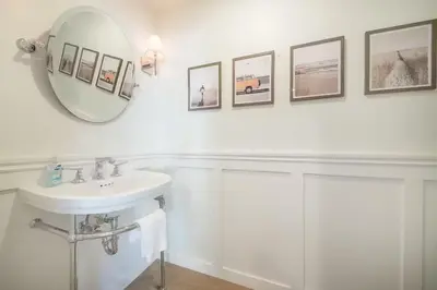 a white bathroom with a sink and a mirror at Cliffside Haven Where Ocean Meets Sky in San Diego