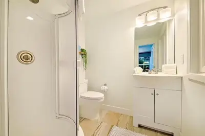 a white bathroom with a toilet and a sink at Cliffside Haven Where Ocean Meets Sky in San Diego
