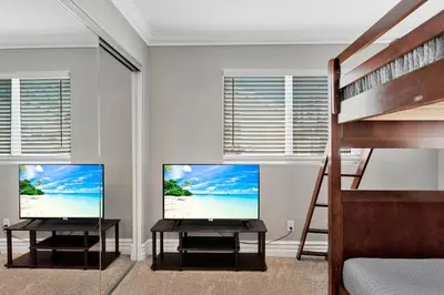 a bedroom with two monitors and a bunk bed at Beach Escape with Patio! 2 Min Walk to Sand & Surf in Newport Beach