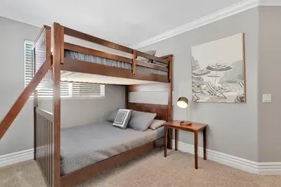 a small bedroom with a bunk bed and a table at Beach Escape with Patio! 2 Min Walk to Sand & Surf in Newport Beach