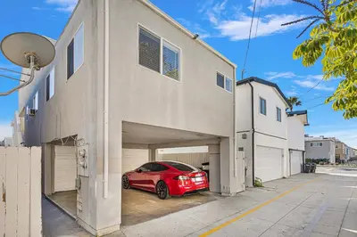 a red car is parked inside of a garage at Beach Escape with Patio! 2 Min Walk to Sand & Surf in Newport Beach