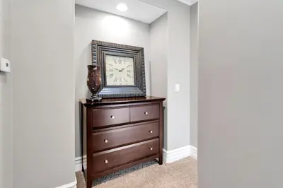 a clock on top of a dresser in a room at Beach Escape with Patio! 2 Min Walk to Sand & Surf in Newport Beach