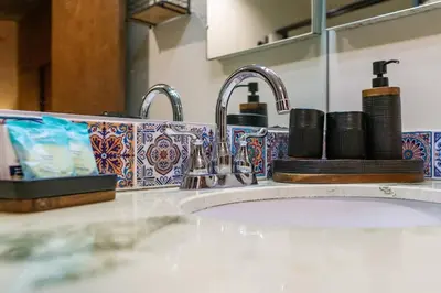 a bathroom counter with a sink and two faucets at Mountain Majesty with AC BBQ Parking in Lemon Grove