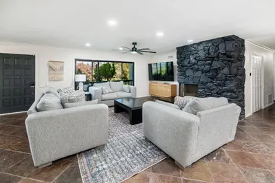 a living room with two couches and a stone fireplace at 5BR Oasis with Pool, Arcade, Sauna in La Mesa