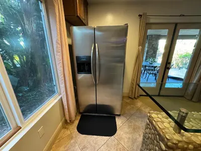 a stainless steel refrigerator in a kitchen next to a window at Guesthouse in Coastal Del Mar, California in San Diego