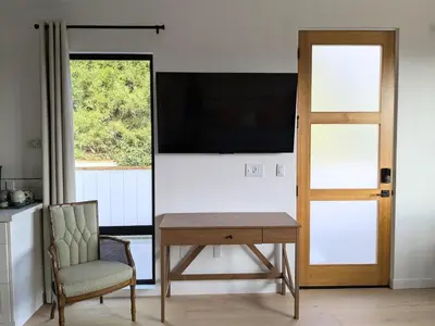 a table and a chair in a room with a television at Newly Built, secluded, and tranquil Nest in Olivenhain in Encinitas
