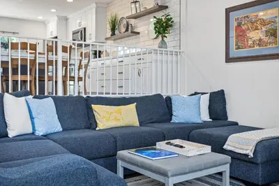 a living room with a blue couch and a table at Live in the Sunshine-DMBC148N in Solana Beach