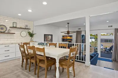 a kitchen and dining room with a white table and chairs at Live in the Sunshine-DMBC148N in Solana Beach
