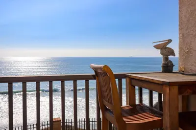 a table and chair on a balcony overlooking the ocean at Sea La Vie - DMST17 in Solana Beach