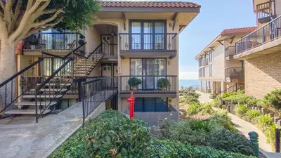a building with a red fire hydrant in front of it at Sea La Vie - DMST17 in Solana Beach