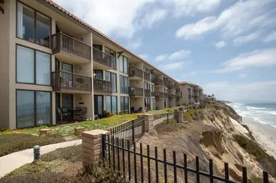 a building on a cliff next to the ocean at Sea La Vie - DMST17 in Solana Beach