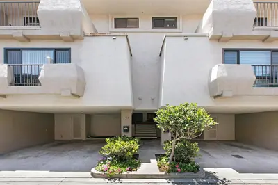 an apartment building with two balconies and two plants at Seaside Shenanigans - DMBC751P in Solana Beach