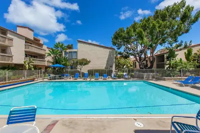 a large swimming pool with chairs at Oceanfront Sea'batical - SBTC212 in Solana Beach