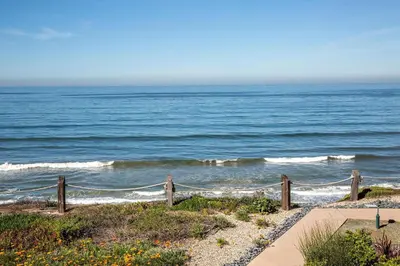 a view of the ocean from a beach with a fence at Oceanfront Sea'batical - SBTC212 in Solana Beach