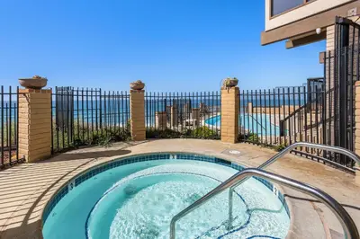 a hot tub on a patio with a fence at Enjoy Some Sea-clusion-DMST25 in Solana Beach