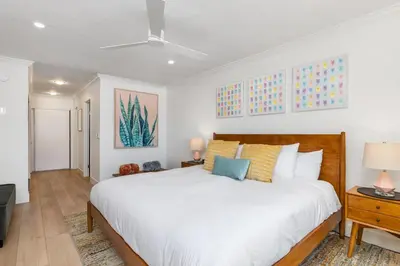 a bedroom with a large white bed and a table at Happy Days - SBTC101 in Solana Beach