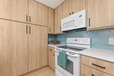 a kitchen with white appliances and wooden cabinets at Happy Days - SBTC101 in Solana Beach