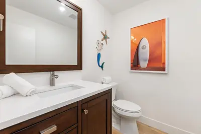a bathroom with a sink and a toilet and a mirror at Happy Days - SBTC101 in Solana Beach