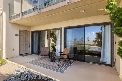 a patio with two chairs and a table on a balcony at Happy Days - SBTC101 in Solana Beach