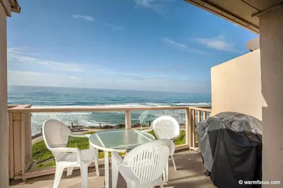 a balcony with a table and chairs and the ocean at Above the Waves - SUR116 in Solana Beach