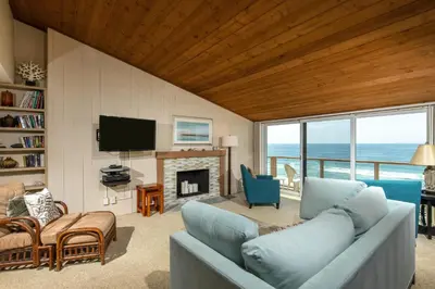 a living room with a blue couch and a fireplace at Above the Waves - SUR116 in Solana Beach