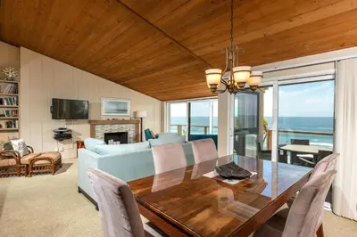 a dining room with a table and a view of the ocean at Above the Waves - SUR116 in Solana Beach