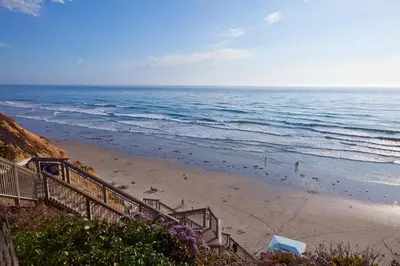 a beach with stairs leading down to the ocean at Serenity By The Sea - SBTC202 in Solana Beach