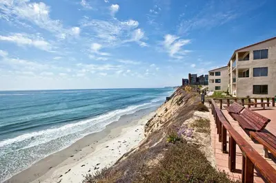 a view of a beach with a building and the ocean at Serenity By The Sea - SBTC202 in Solana Beach