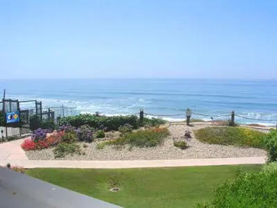 a garden with flowers and the ocean in the background at Serenity By The Sea - SBTC202 in Solana Beach