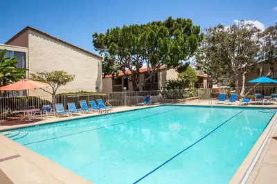 a large swimming pool with chairs and umbrellas at Sunnyside Up! - SBTC213 in Solana Beach