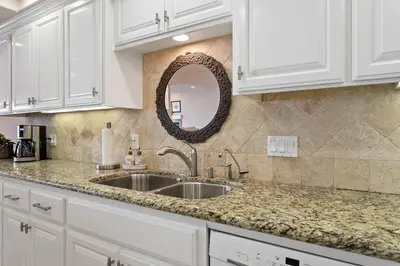 a kitchen counter with a sink and a mirror at Bella Vista - SUR111 in Solana Beach