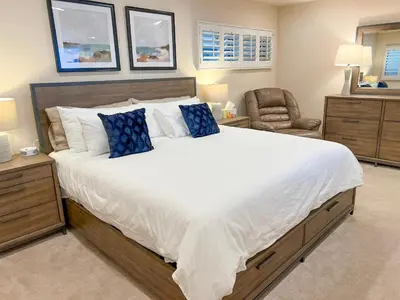 a bedroom with a large bed with blue pillows at Bella Vista - SUR111 in Solana Beach