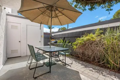 a table and chairs with an umbrella on a patio at Keepin' It Real - SB851VA in Solana Beach