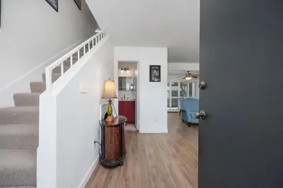 a living room with stairs and a lamp on a table at Keepin' It Real - SB851VA in Solana Beach