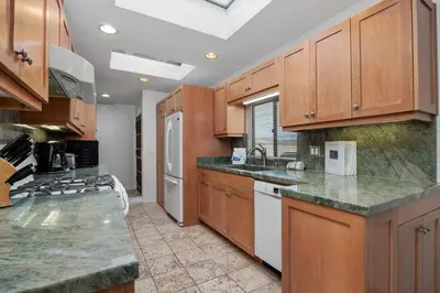 a kitchen with wooden cabinets and marble counter tops at Paradise Found! - SBTC336 in Solana Beach