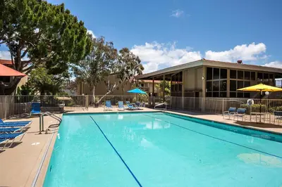 a large swimming pool with chairs and a building at Paradise Found! - SBTC336 in Solana Beach