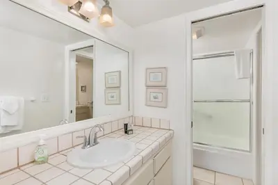 a white bathroom with a sink and a mirror at Surf, Sun, Sand - SUR106 in Solana Beach