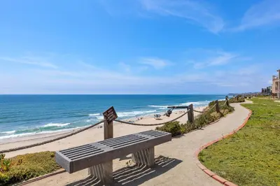 a bench sitting on a path near the beach at Surf, Sun, Sand - SUR106 in Solana Beach
