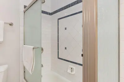 a bathroom with a tub and a shower with a mirror at Let the Sea Set you Free SUR35 in Solana Beach
