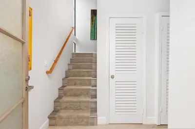 a stairway with a white door leading up to a staircase at Let the Sea Set you Free SUR35 in Solana Beach