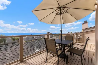 a patio table with an umbrella on a deck at Let the Sea Set you Free SUR35 in Solana Beach