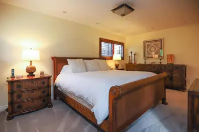 a bedroom with a bed and a dresser with a lamp at Adventure Awaits - SUR15 in Solana Beach