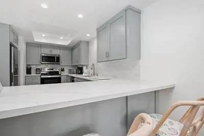 a kitchen with white cabinets and white counter tops at Tranquil Living - SUR4 in Solana Beach