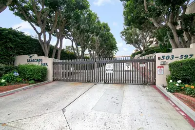 a gate in a driveway with trees and bushes at Tranquil Living - SUR4 in Solana Beach