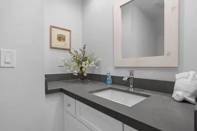 a bathroom with a sink and a mirror and flowers at Sun, Sand, & Vitamin Sea - SUR5 in Solana Beach