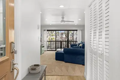 a living room with a blue couch and a balcony at Sun, Sand, & Vitamin Sea - SUR5 in Solana Beach